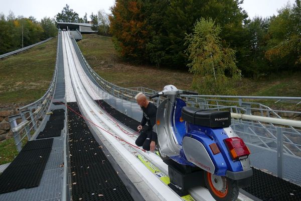 Schachermayr hoists a Vespa up a ski jumping hill.